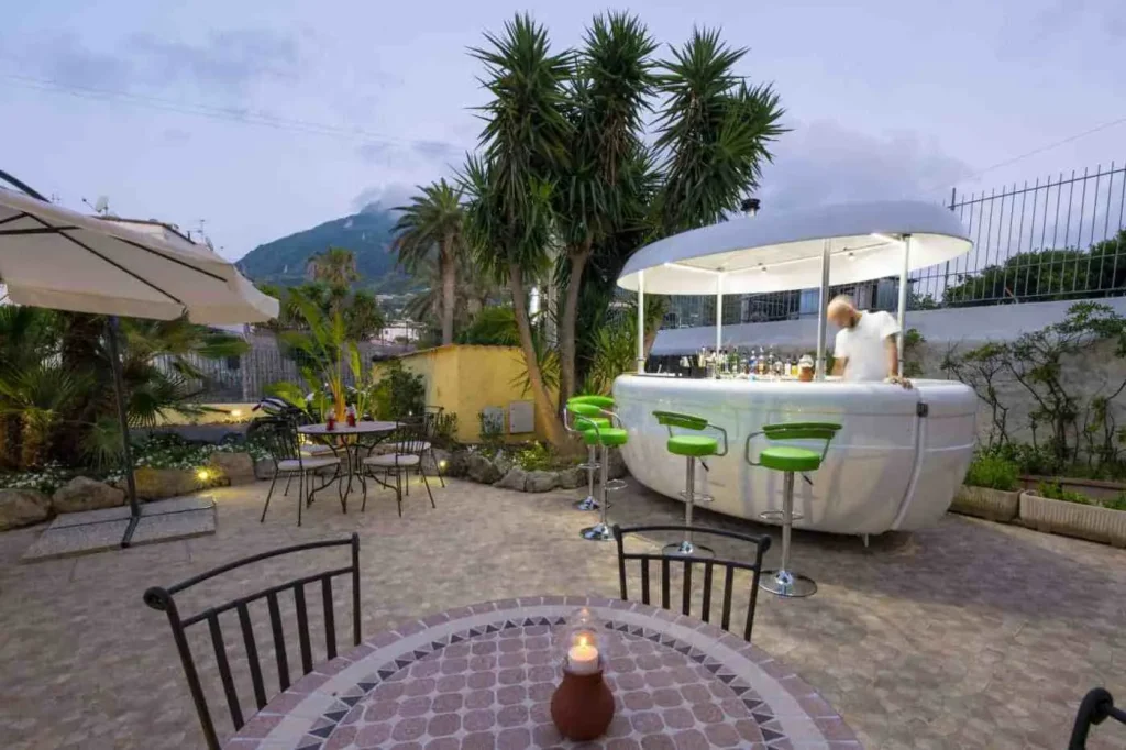 Bar all'aperto nel giardino, la sera, con sgabelli e tavolini