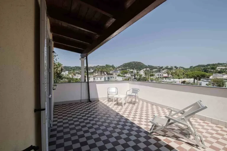Balcone arredato con sdraio, affacciato sul giardino e sulle colline