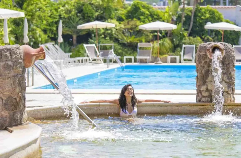 Ospite rilassata sotto le cascate cervicali della piscina termale