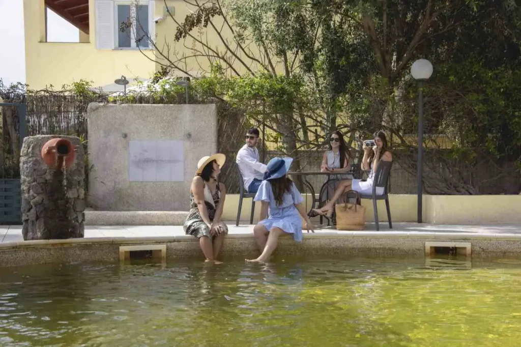 Ospiti sedute sul bordo della vasca termale con i piedi in acqua