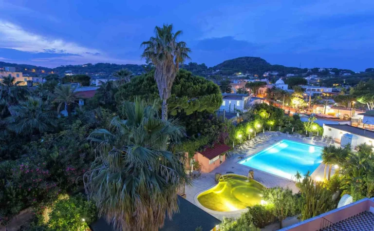 Il giardino visto dall'alto la sera, con la piscina e la vasca termale illuminate